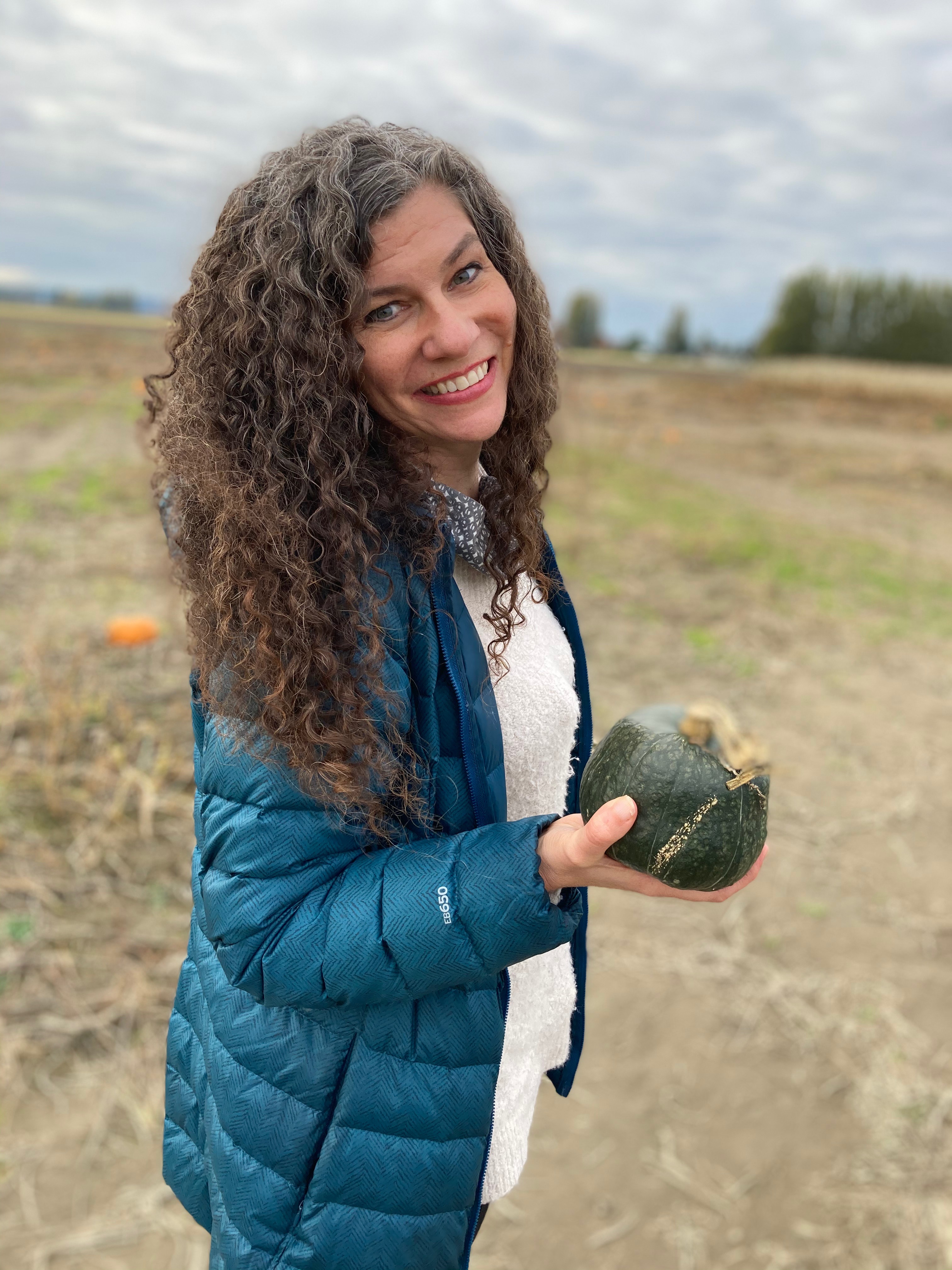 Jenni holding a squash at the pumpkin patch